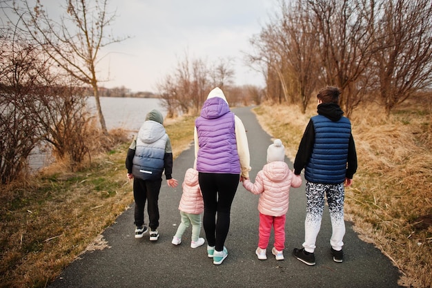 湖のほとりの小道を子供たちと一緒に歩いている母親の背中