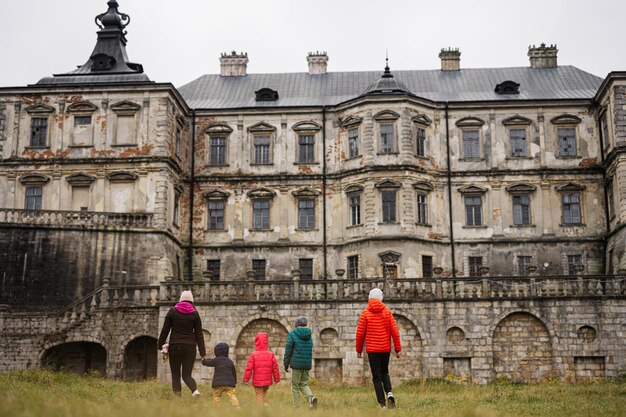 Back of mother with four kids visit Pidhirtsi Castle Lviv region Ukraine Family tourist