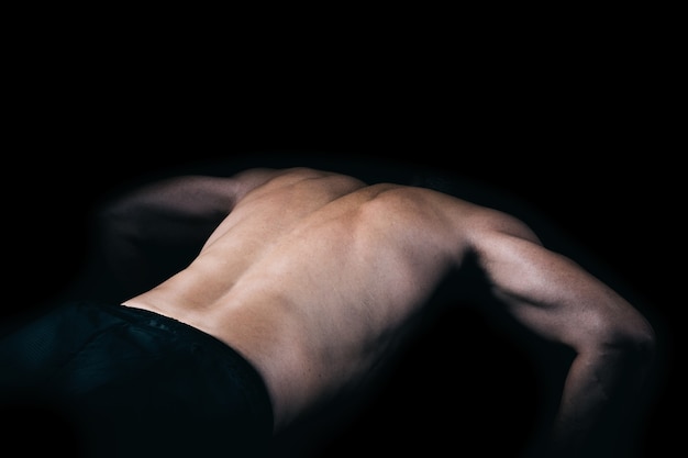 Back of a muscular man doing pushups