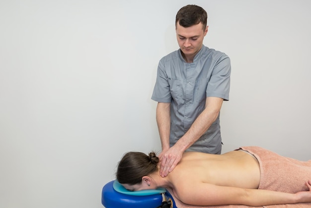 Foto massaggio al collo alla schiena massaggio al collo alla schiena una donna riceve un massaggio sdraiata su un lettino da massaggio