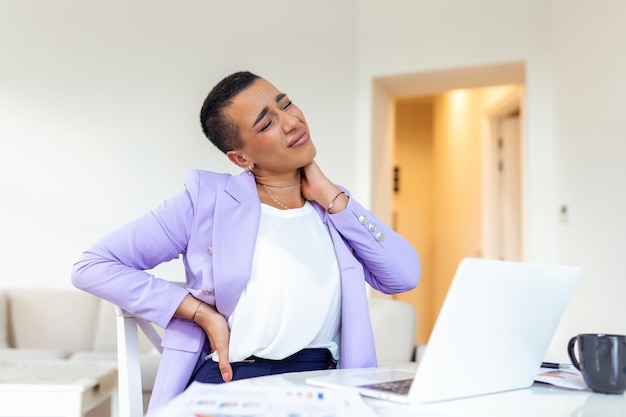 Back Pain Bad Posture Woman Sitting In Office Young woman suffering from back pain while working on laptop at home