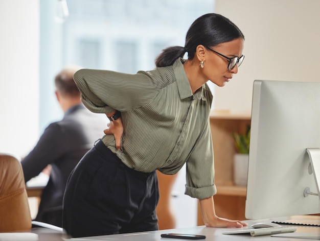 Photo back pain woman in office at desk with computer and burnout deadline pressure and glasses at work tired overworked and overwhelmed businesswoman at pc with injury cramp or muscle ache at startup