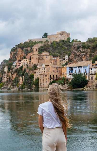 Back photography of caucasian woman with long blonde hair looking the village