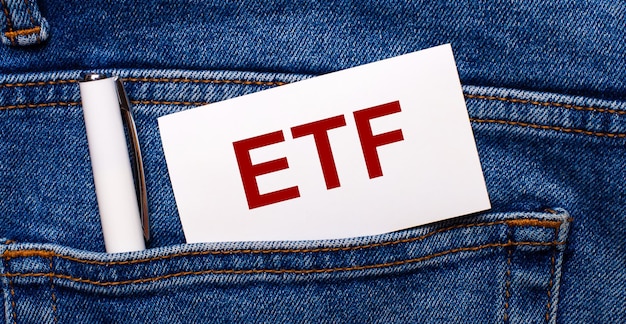 청바지 뒷주머니에는 흰색 펜과 ETF Exchange Traded Funds라는 텍스트가 있는 흰색 카드가 들어 있습니다.