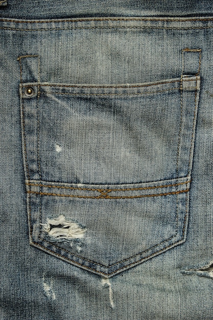Задний карман потертых джинсов
