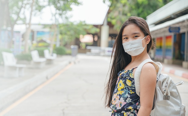 Back to school. asian child girl wearing face mask with backpack  going to school. coronavirus pandemic.New normal lifestyle.Education concept.