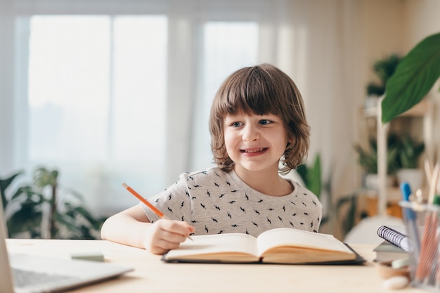 学校に戻る。ラップトップを持って家にいる少年