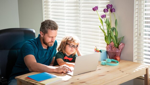 Back to school busy father and son in glasses use computer at home family blog