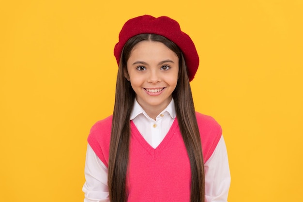 Back to school cheerful kid in beret smiling child has long hair skin beauty tween and youth casual fashion happy french teen girl on yellow background childhood happiness