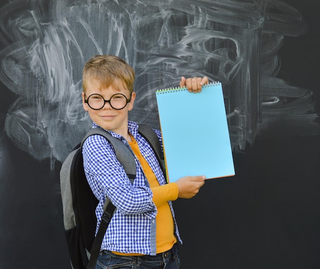 Foto ritorno a scuola un bambino delle elementari con un libro e una borsa