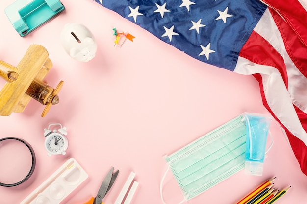 Back to school or college concept school supplies stationery American flag and surgical face mask