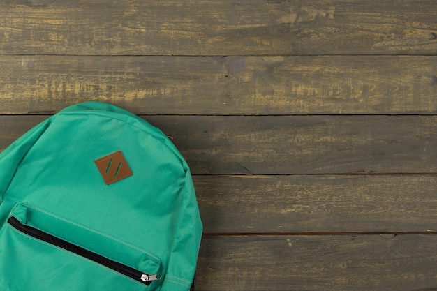 Back to school concept blue backpack on wooden backgroung