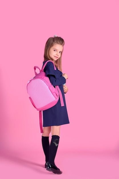 Back to school concept Half turned photo portrait of lovely confident beautiful clever girl with copybook notebook wearing school uniform dress pink bright backpack isolated