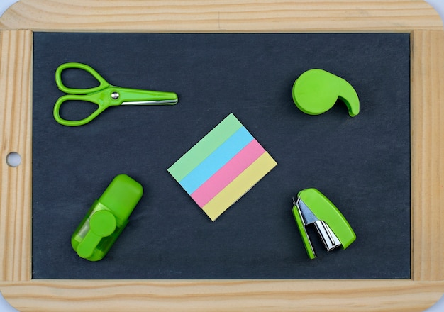  Back to school concept: office and school supplies on a blackboard