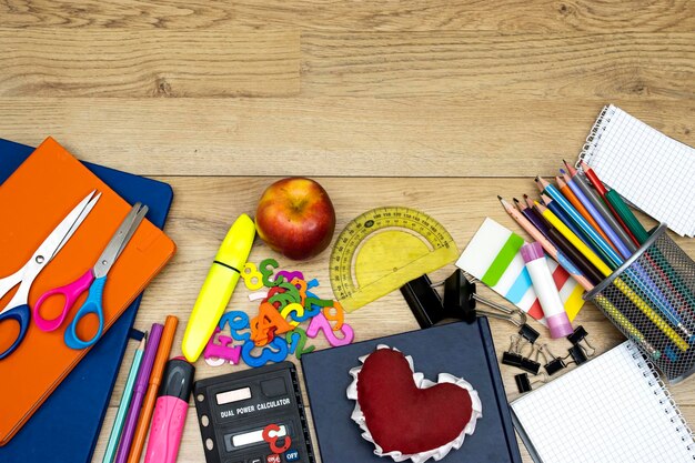 Foto torno alla scuola concetto scatola per matite e libri quaderni e appunti adesivi e calcolatrice con perni.