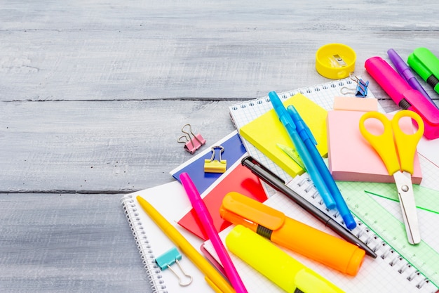 Foto torna al concetto di scuola. rifornimenti di istruzione scolastica sui bordi di legno grigi