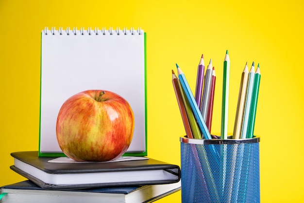 Back to school concept School supplies and books on yellow background Place for text