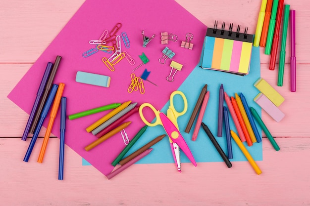 Back to school concept school supplies markers crayons pink and blue paper scissors eraser and other accessories