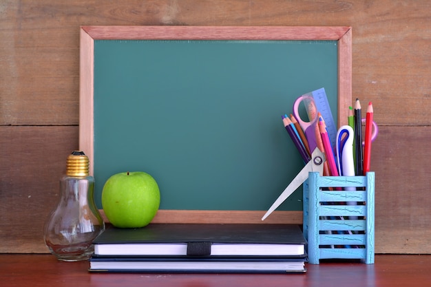 黒板の前のテーブルにリンゴと学校に戻るコンセプト