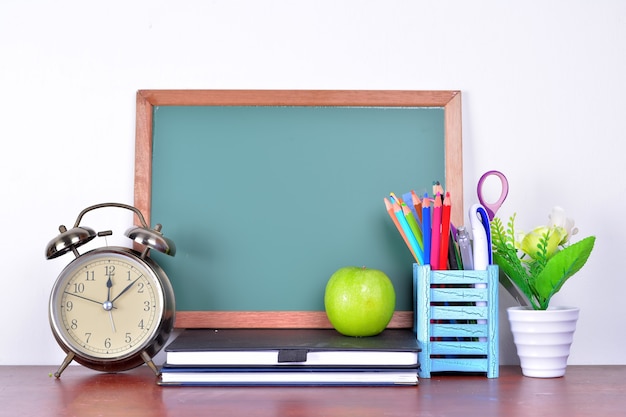 Back to school concept with books and alarm clock with chalkboard