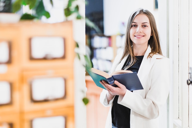 Foto di nuovo al concetto della scuola con la donna che studia nella biblioteca