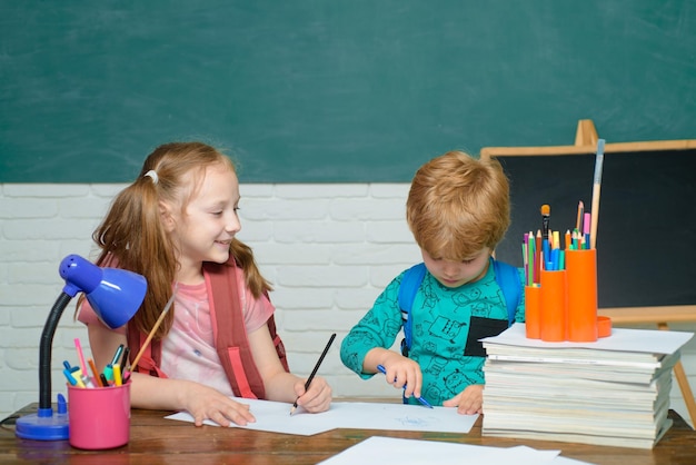 Back to school cute little preschool kid boy with little child girl in a classroom school kids