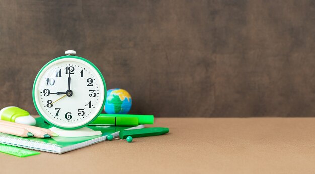 Back to school and education concept Stationery for studies and clock near the chalkboard and place for text