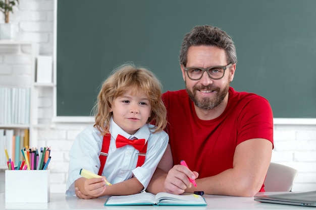 Back to school father teacher helping a son boy in school lessons