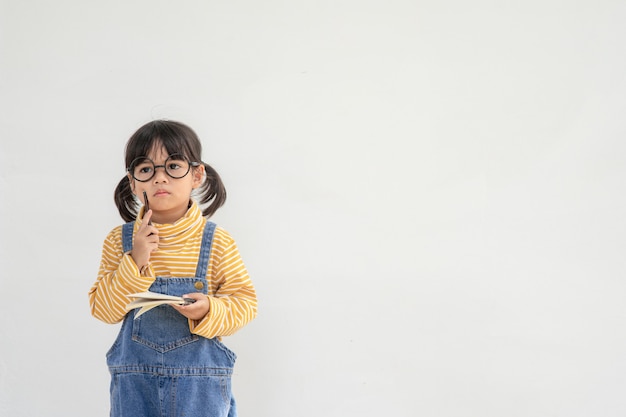 学校に戻る。白い背景の上の眼鏡の面白い女の子。本を持った小学校の子供。教育