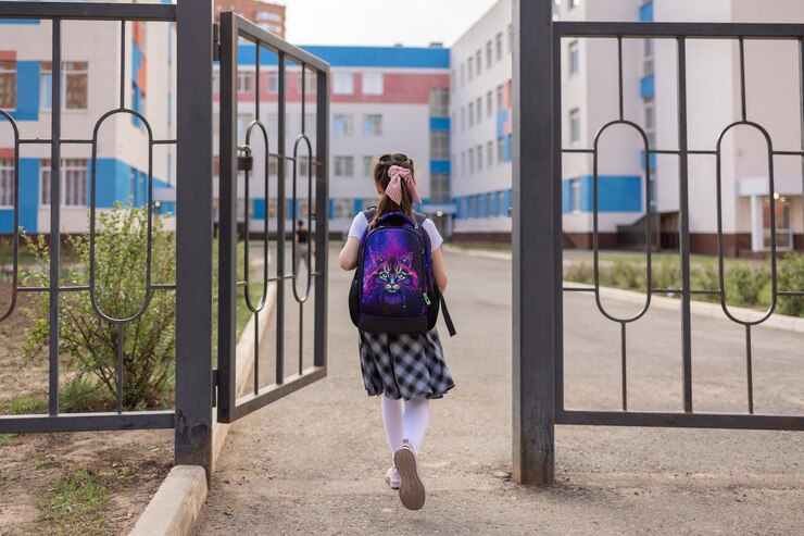 学校に戻る制服を着た女の子がバックパックを背負って通学授業開始秋の初日小学生
