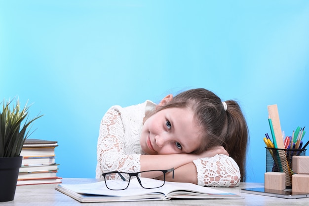 Ritorno a scuola. felice carino bambino laborioso è seduto a una scrivania in casa. il bambino sta imparando in class.quarantine.kid sta imparando in casa.