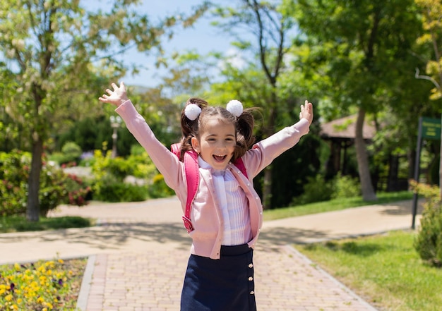 学校に戻る幸せな笑顔の子供は小学校に行くランドセルを持った子供は屋外で