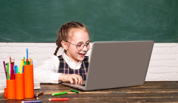 Back to school and home schooling Little Student pupil with laptop Funny little child having fun on