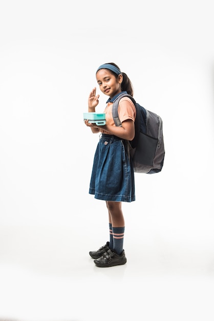 Back to school - Indian girl in school uniform, standing isolated over white background ready to leave