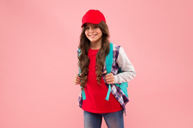 Winner gives what it takes. Happy winner hold school bag pink background.  School contest winner. Happy girl make winner gesture. Celebrating victory  or success. Supreme champion. Knowledge is power Stock Photo 