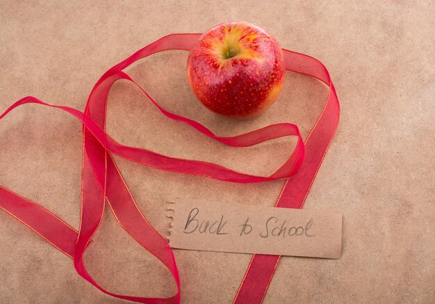 Back to school lettering with apple and a red ribbon