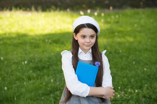 Back to school look. Little child back to school. Little girl hold book in uniform. September 1. Back to school. School fashion. Education and study. Back to learning. Startup.