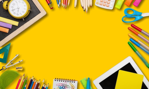 Foto scena in stile ritorno a scuola o in ufficio con materiale scolastico multicolore su giallo,