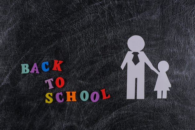 Back to school. Paper father with daughter on chalk blackboard with text back to school