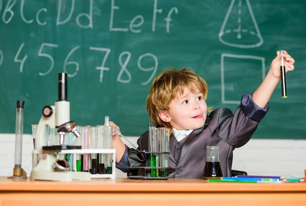 Back to school pupil looking through microscope student do\
science experiment with microscope in lab small boy using\
microscope at school lesson small boy at science camp modern\
school