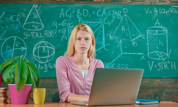 Back to school. Remote education. Student adorable blonde girl classroom chalkboard background. STEM concept. Formal education. Confident woman with laptop working online teacher. Modern education