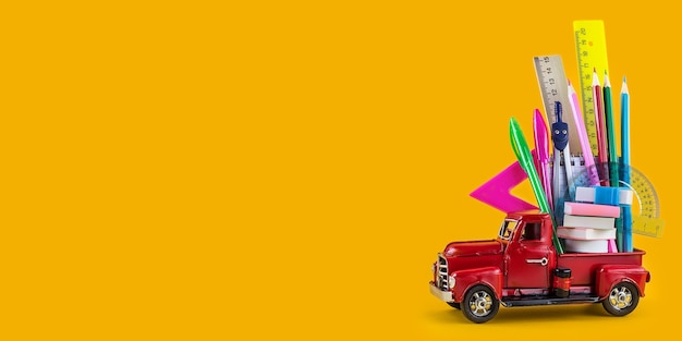 Back to school sale background. Car delivering School stationery on yellow background. Composition with different school stationery on color background. Education concept. Long wide banner