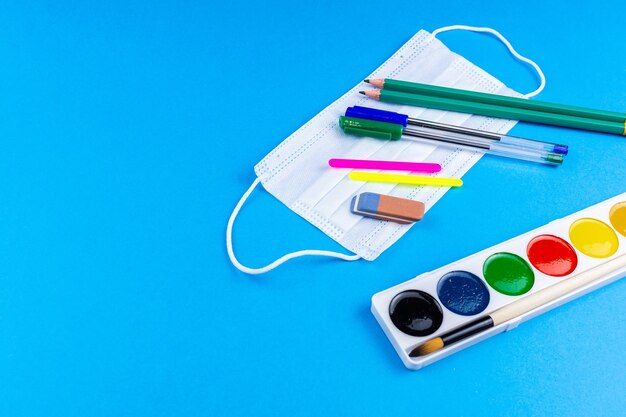 Back to school. School accessories on a blue background. photo banner, top view, space for text.