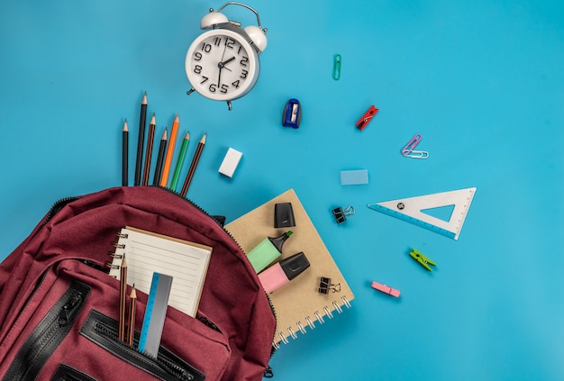 Di nuovo a scuola . borsa di scuola e forniture su blu