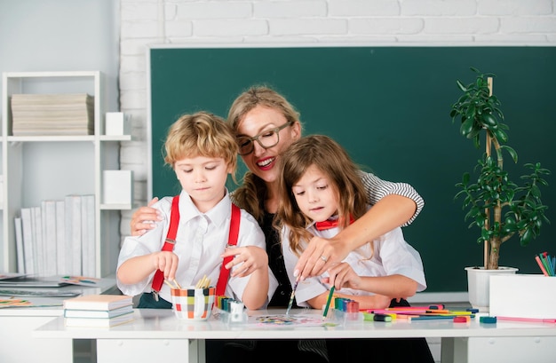 学校に戻る 先生と絵を描く 小学校の子供たち 痛みのレッスンで勉強する