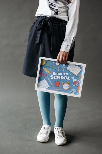 Photo back to school school supplies on blackboard happy elementary school student in the classroom