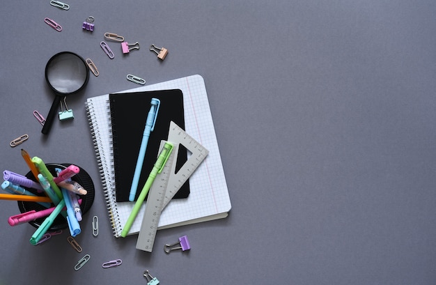 Back to school. school supplies: notebook, pen, pencil on a gray background. view from above. office tools