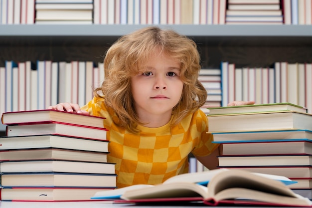 Back to school schoolboy pupil reading book at school kid doing homework sitting at table by books