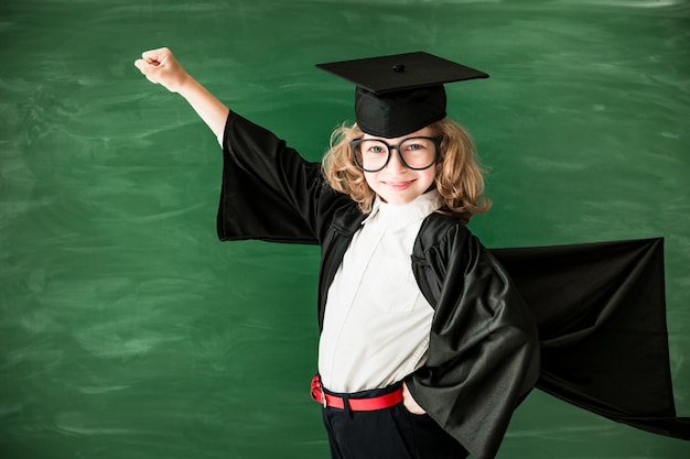 Back to school Schoolchild in class Happy kid against green blackboard Education and creativity