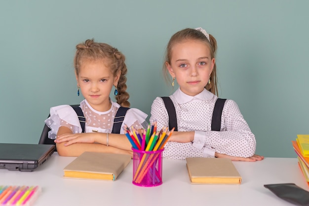 Back to school schoolgirls write draw in a notebook sitting at the table and do homework